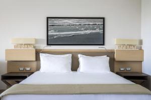 a bedroom with a large bed with two pillows at Capovaticano Resort Thalasso Spa in Capo Vaticano