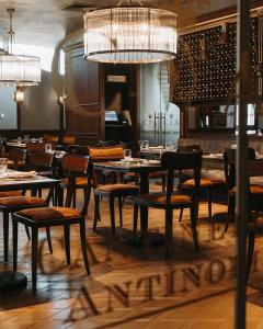 a restaurant with tables and chairs in a room at The Veil Hotel in Astana