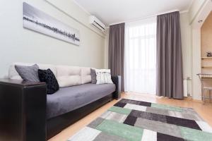 a living room with a couch and a rug at VIP Apartments 24/7 in Minsk