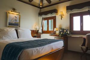 um quarto com uma cama, uma escrivaninha e janelas em Hotel Bucintoro em Veneza