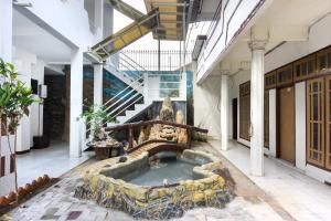 a building with a fountain in the middle of a courtyard at RedDoorz At Pujon Malang in Batu