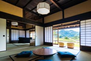 uma sala de estar com uma mesa e uma grande janela em Setouchi Cominca Stays Hiroshima Chojaya em Shōbara