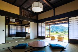 sala de estar con mesa y ventana grande en Setouchi Cominca Stays Hiroshima Chojaya en Shōbara