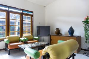 a waiting room with chairs and a flat screen tv at RedDoorz At Pujon Malang in Batu