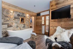 a bathroom with a tub and a stone wall at Hotel Sonnberg in Saalbach-Hinterglemm