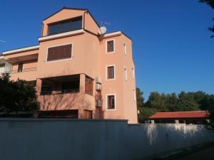 un gran edificio rosa detrás de una valla en Apartments Centener, en Rovinj