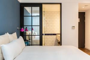 a bedroom with a large white bed and a shower at 朵兒dor韓國汗蒸幕 동대문점 商務旅店 in Taipei