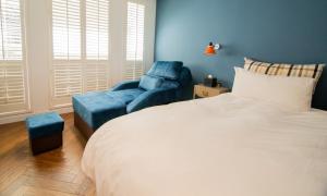a bedroom with a bed and a blue chair at 朵兒dor韓國汗蒸幕 동대문점 商務旅店 in Taipei
