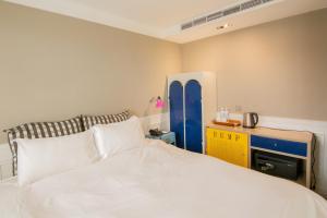 a bedroom with a white bed and a blue cabinet at 朵兒dor韓國汗蒸幕 동대문점 商務旅店 in Taipei