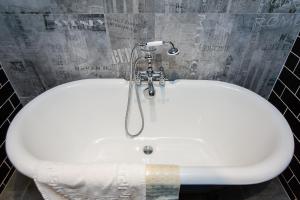 a white bath tub in a bathroom at 朵兒dor韓國汗蒸幕 동대문점 商務旅店 in Taipei
