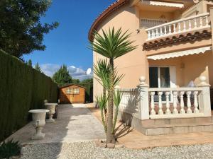 a palm tree in front of a house at MEDDAYS CHALET BELLAVISTA in Miami Platja