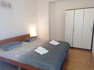 a bedroom with a bed with two towels on it at Apartments Smile in Split