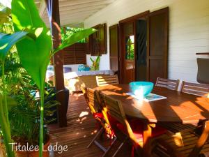 einen Holztisch und Stühle auf einer Terrasse in der Unterkunft Titalee Lodge 3 Villas autour d'une piscine in Saint-François
