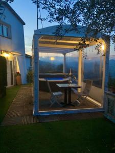 een tuinhuisje met een tafel en stoelen op een terras bij Villa Tamara Country & Spa Suites in Montefiore Conca