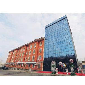 un gran edificio de cristal con flores delante en VELARA HOTEL en Tashkent