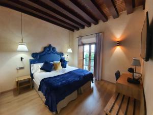 a bedroom with a blue bed and a window at Boutique Puerta Real in Seville