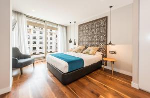sypialnia z łóżkiem, krzesłem i oknem w obiekcie Gran View Apartments w Madrycie +37 zdjęć
