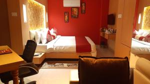 a red room with a bed and a table and chairs at THE RED VELVET HOTEL in Patna