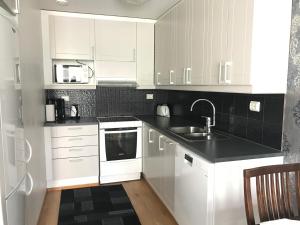 a white kitchen with white cabinets and a sink at Vaasa Apartments 4 in Vaasa +12 photos
