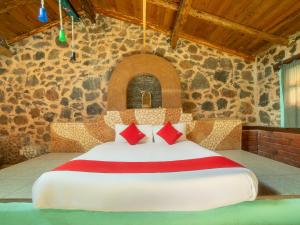 ein Schlafzimmer mit einem großen Bett in einer Steinmauer in der Unterkunft Cabañas Tres Joyas in San Miguel Regla