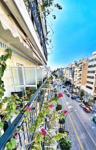 a balcony of a building with flowers and a street at Noufara in Piraeus