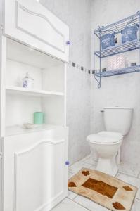 ein weißes Bad mit einem WC und einem Teppich in der Unterkunft Gite Barbey in Sainte-Marie-du-Mont