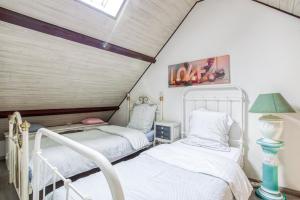 - 2 lits dans une chambre mansardée dans l'établissement Gite Barbey, à Sainte-Marie-du-Mont