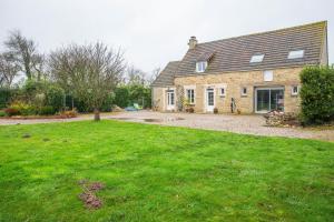 a brick house with a grass yard in front of it at Gite Barbey in Sainte-Marie-du-Mont