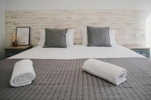a large bed with two towels on top of it at BBarcelona Fira Superior Flats in Barcelona