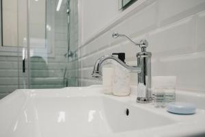 a bathroom sink with a faucet and a mirror at BBarcelona Fira Superior Flats in Barcelona
