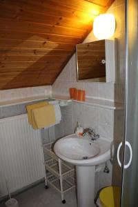 a bathroom with a sink and a wooden ceiling at Mekina Guesthouse in Maribor