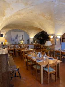 ein Restaurant mit Holztischen und -stühlen und einer Decke in der Unterkunft Auberge De La Foret in Auris