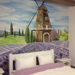 1 dormitorio con un mural de un molino de viento en Pogar Inn, en Slavske