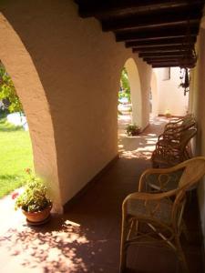 a row of chairs sitting under an archway with a row at Hotel Villa Mediterranea in Noto Marina