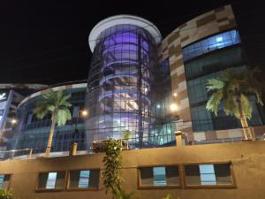 um edifício com palmeiras em frente em PrideInn Plaza Nairobi Airport em Nairobi