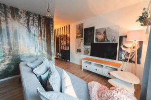 un salon avec un canapé bleu et une télévision dans l'établissement EastSide Apartments-Apartament nr 6, à Świeradów-Zdrój