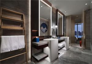 a bathroom with two sinks and a large mirror at HUALUXE Nanjing Yangtze River, an IHG Hotel in Nanjing