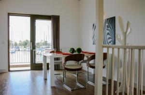 a dining room with a white table and chairs at Roggebroek 13 in Stavoren +12 photos