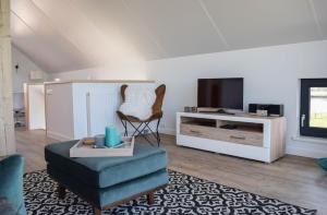 a living room with a chair and a tv at Roggebroek 13 in Stavoren