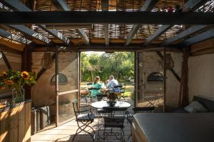 dwoje osób siedzących przy stole na patio w obiekcie De Heeren van Tuil w mieście Tuil