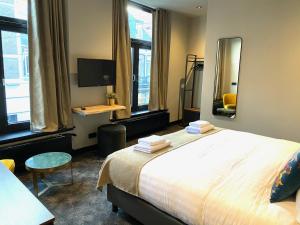 a bedroom with a large bed and a mirror at Hotel de Prince in Nijmegen