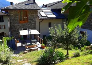 a house with a patio with a table and chairs at agriturismo farmhouse la barberina in Calceranica al Lago