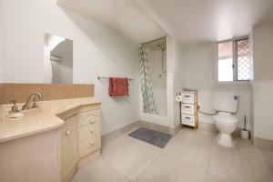 een witte badkamer met een toilet en een wastafel bij Birdsong Ridge - where nature meets the ocean. in Agnes Water