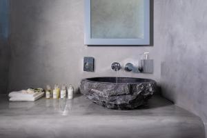 a bathroom with a large stone sink in a room at Santa Irina Luxury Sunny Lofts in Perivolos