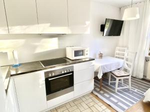 a small kitchen with a microwave and a table at Ferienwohnungen Anna Altmann in Furth im Wald