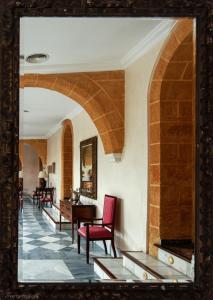 a mirror in a room with chairs and a table at Palacio Marques de la Gomera in Osuna