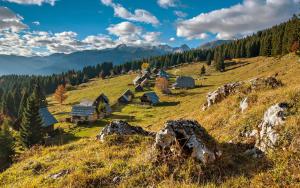 un groupe de cabanes sur une colline dans les montagnes dans l'établissement PR`Cajhn, à Radovljica