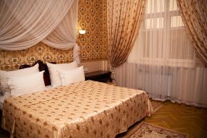 a bedroom with a bed and a window with curtains at INTOURIST Hotel in Volgograd