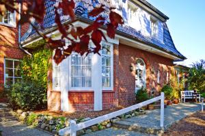 a red brick house with a white door at Hotel kleine Auszeit - Adults Only in Sankt Peter-Ording