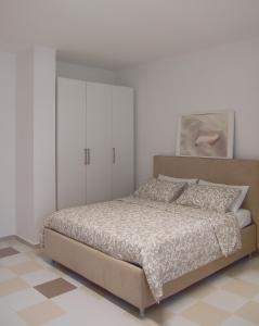 1 dormitorio con 1 cama y armarios blancos en Le Rose Beach & Suites appartamenti fronte mare a Villarosa, en Martinsicuro